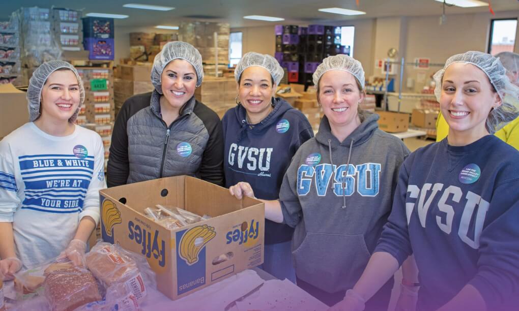 group of women at Kids' Food Basket, packing boxes with food
